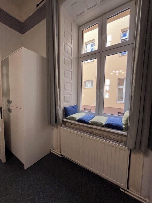 A room with a window, a radiator, and a door. - GIRLS Dorm Apartment  (Kraków)
