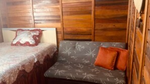 Ein Zimmer in einer Holzhütte mit einem Bett und einer Couch.