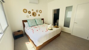 A bedroom with a bed, bedside tables, a wardrobe, and decorative wall art.