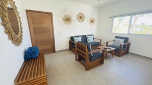 A living room with a sofa, two armchairs, a coffee table, a wooden bench, and a mirror.