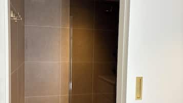 Een douche, handdoeken, zeep, toiletpapier