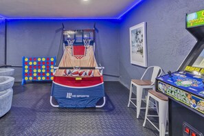 Ein Zimmer mit Basketballkorb, Dartscheibe und Spielgerät.