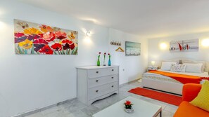 A modern bedroom with a bed, dresser, and artwork.