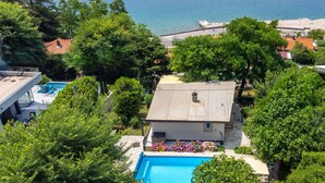 A residential property with a swimming pool, surrounded by lush greenery and a view of the sea. - Villa Relax with pool&beachfront by Villas Guide (Bakar)