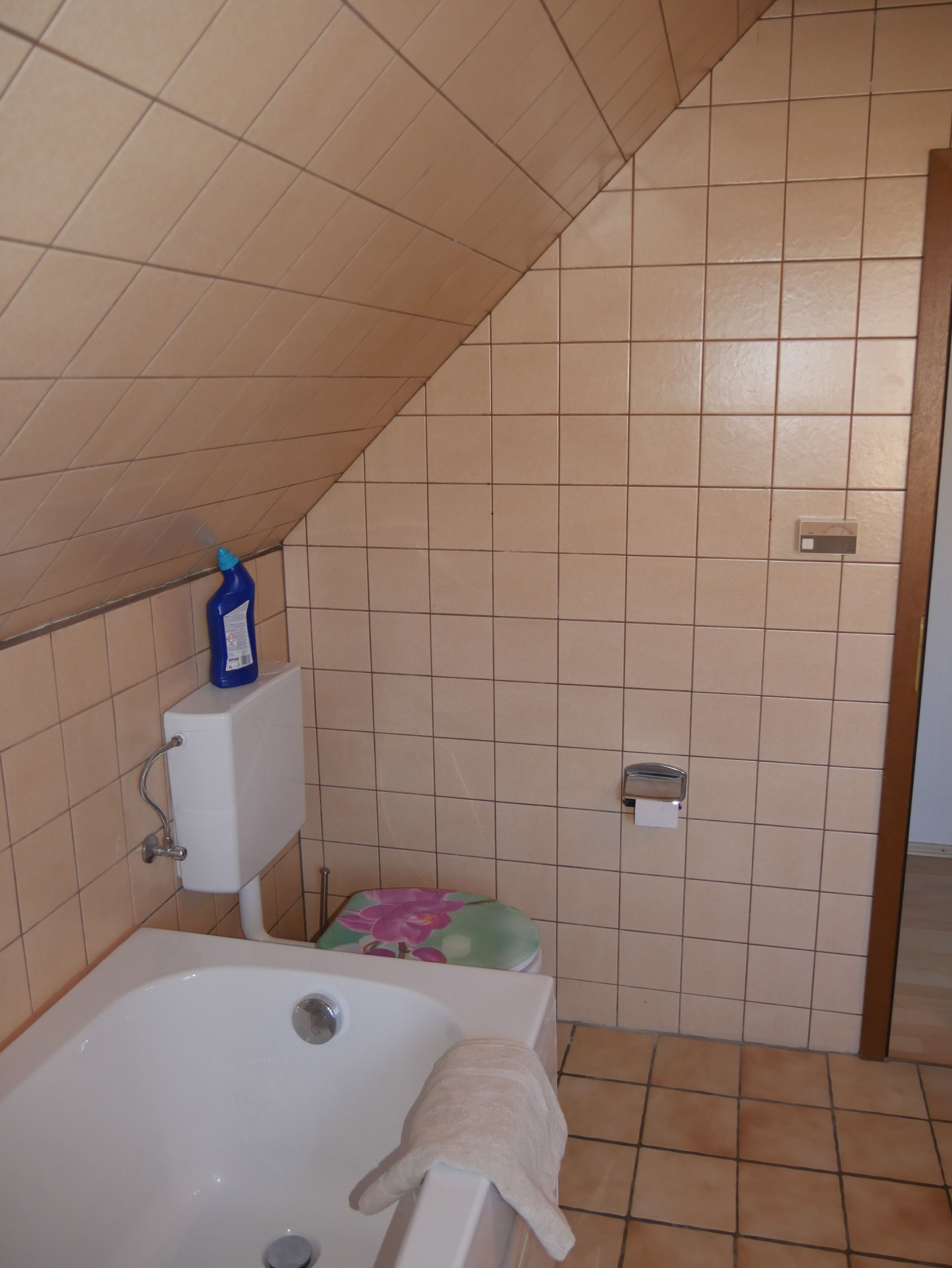 A bathroom with a bathtub, toilet, and a shower area.