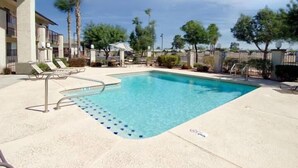 A rectangular pool with a clear blue water, surrounded by a concrete deck. - Hotel Rising (Phoenix)