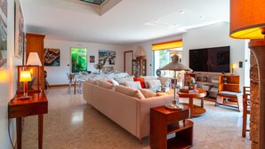 Una sala de estar moderna con un sofá grande, una mesa de comedor y un televisor.