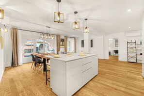 A modern kitchen with a central island, pendant lighting, and a view of the city.