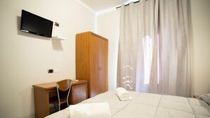 A hotel room with a bed, a desk, a wardrobe, and a TV mounted on the wall. - Hotel The Dream  (Rome)