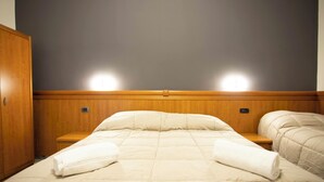 A hotel room with a large bed, wooden headboard, two bedside tables, and two wall-mounted lights. - Hotel The Dream  (Rome)
