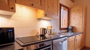 Una cocina moderna con armarios de madera, electrodomésticos de acero inoxidable y un reloj digital.
