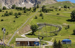 A mountain landscape with a ski lift, a wooden building, and a blue tent. - CASA-Chalet des Ponts : Évasion au Col Madeleine (Saint-François-Longchamp)