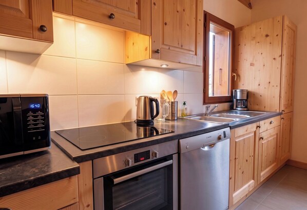 Een moderne keuken met houten kastjes, een roestvrijstalen fornuis en een Bosch vaatwasser.