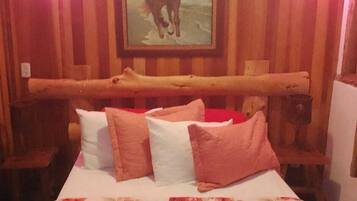 Ein Zimmer mit einem Bett, Holzwänden, einem Pferdegemälde und einem hölzernen Bettgestell.