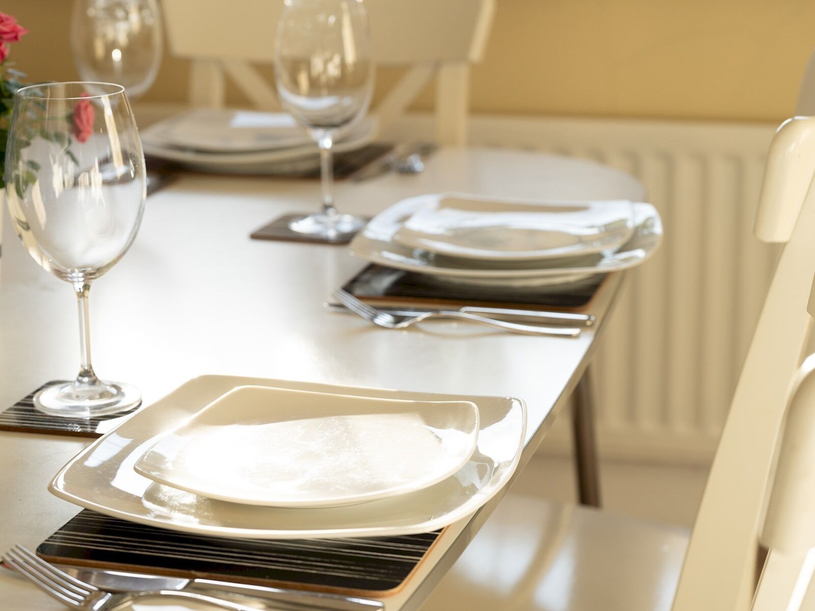 Une table à manger élégamment dressée, avec des assiettes, des couverts et des verres.