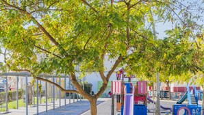 Un parque infantil con estructuras de juego coloridas y una zona de estar cubierta.