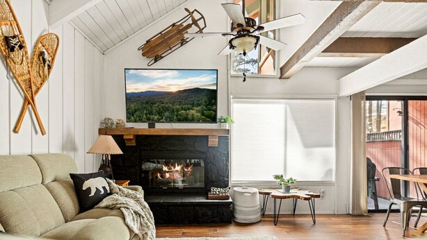 A cozy living room with a fireplace, a sofa, and a television mounted above it. - Summit Slope Side + Steps 2 Slopes! (Big Bear Lake)