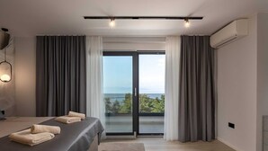 Un dormitorio moderno con cama, vistas al exterior y aire acondicionado.