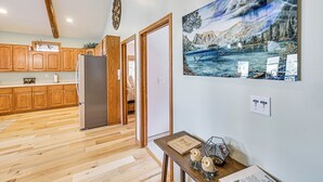Eine Küche mit Holzausstattung, einem Kühlschrank und einem Essbereich mit Tisch und Stühlen.