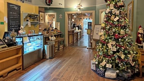 Un interior acogedor con un árbol de Navidad, una barra de cafetería y una zona de recepción.