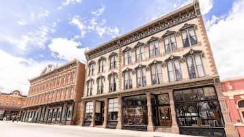 A row of historic buildings with large windows and ornate facades.