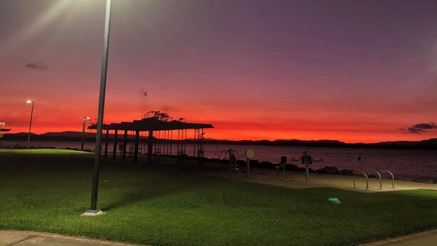 A park with a gazebo, exercise equipment, and a body of water during sunset. - Space and tranquillity at Red Door Cottage (Cooktown)