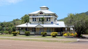 A two-story building with a sign reading "Kingdom Hall Jehovah's Witnesses" and a year "1879" on the facade. - Space and tranquillity at Red Door Cottage (Cooktown)