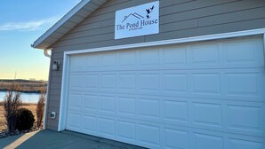 Een gebouw met een garagepoort en een bord waarop staat: The Pond House at Silver Lake.