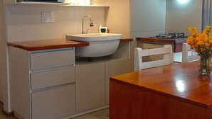 A kitchen with a microwave, sink, and wooden counter. - Casa del Condor (San Carlos de Bariloche)