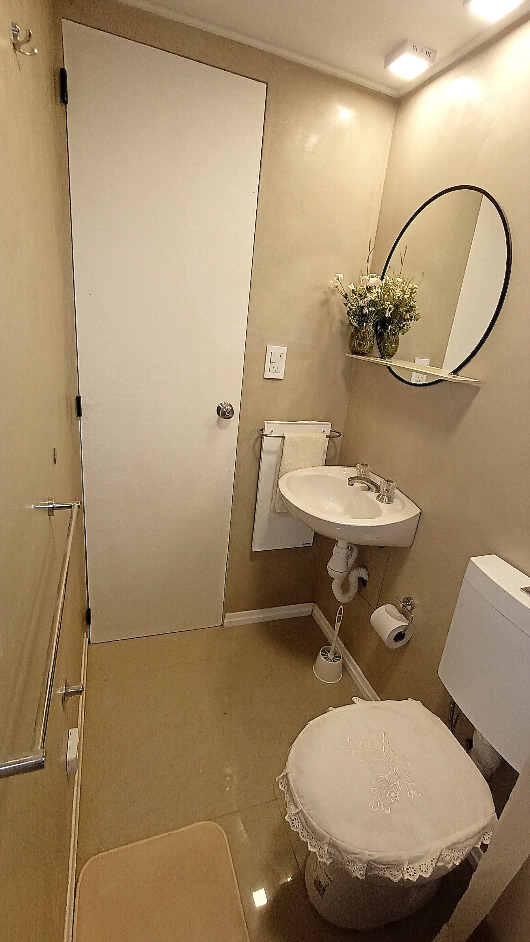 Een badkamer met een wit toilet, een wastafel, een spiegel en een douche.