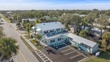 A two-story building with a flat roof, a parking lot, and a pedestrian crossing.