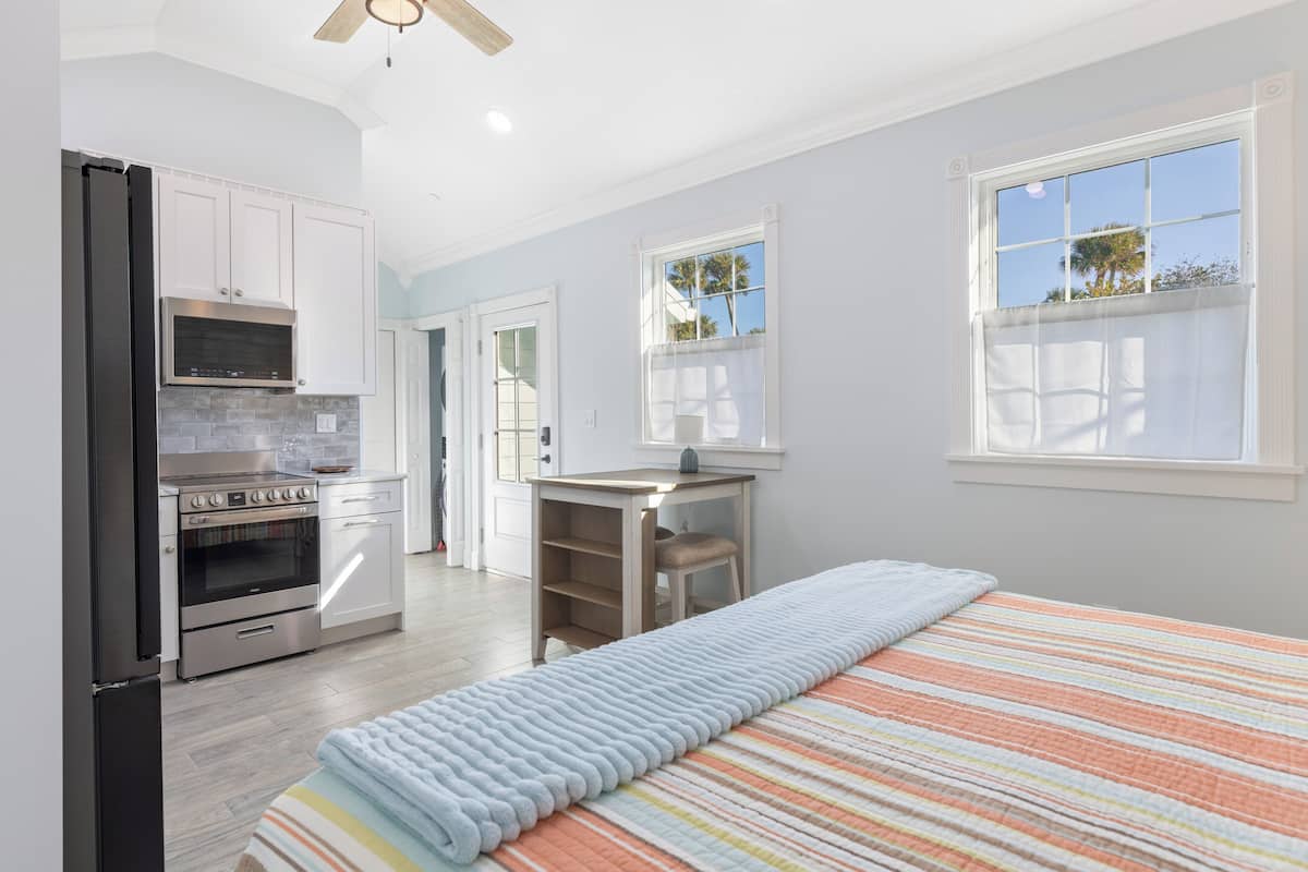 A modern kitchen with white cabinets, a built-in oven, and a microwave.