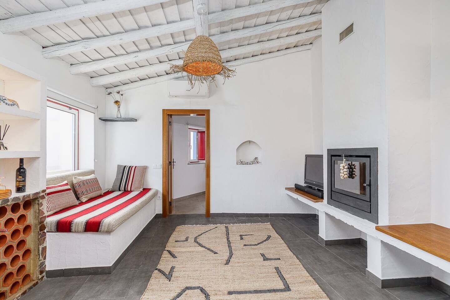 A modern living room with a sofa, TV, and a decorative hanging light.