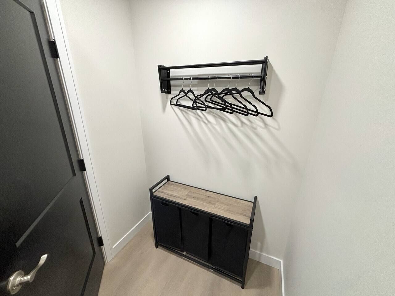 A hallway with a coat rack and a bench.