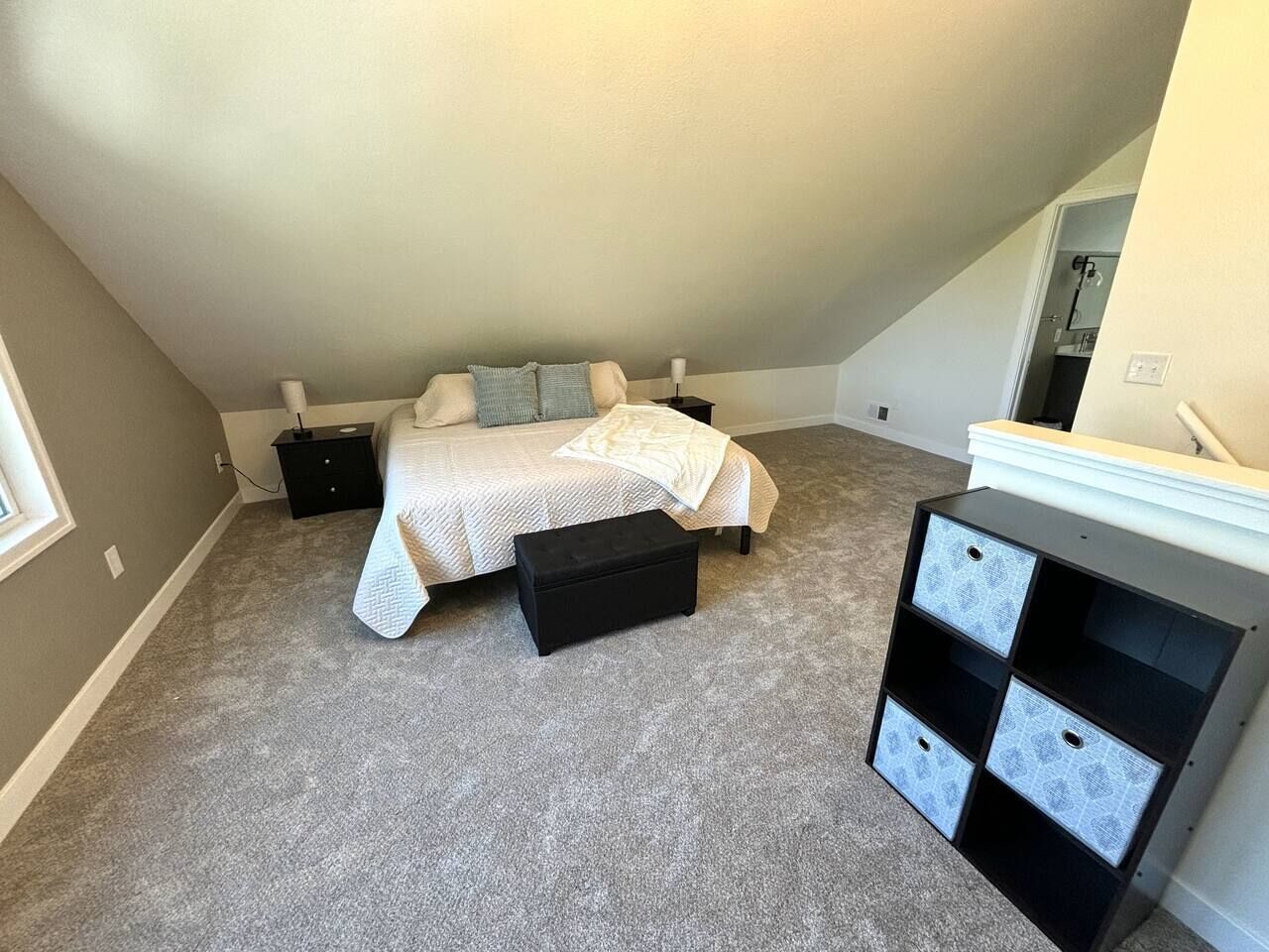 Ein Schlafzimmer mit Bett, Nachttisch, Kommode und Teppichboden.