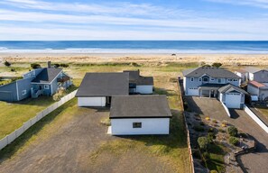 A residential area with houses and a beach in the background.