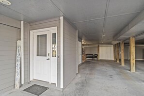 Un edificio con una puerta blanca, un banco y un poste de madera que dice 'BEACH HOUSE'.