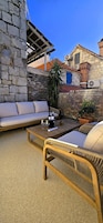 Un espacio al aire libre con sofá, sillas y una mesa.