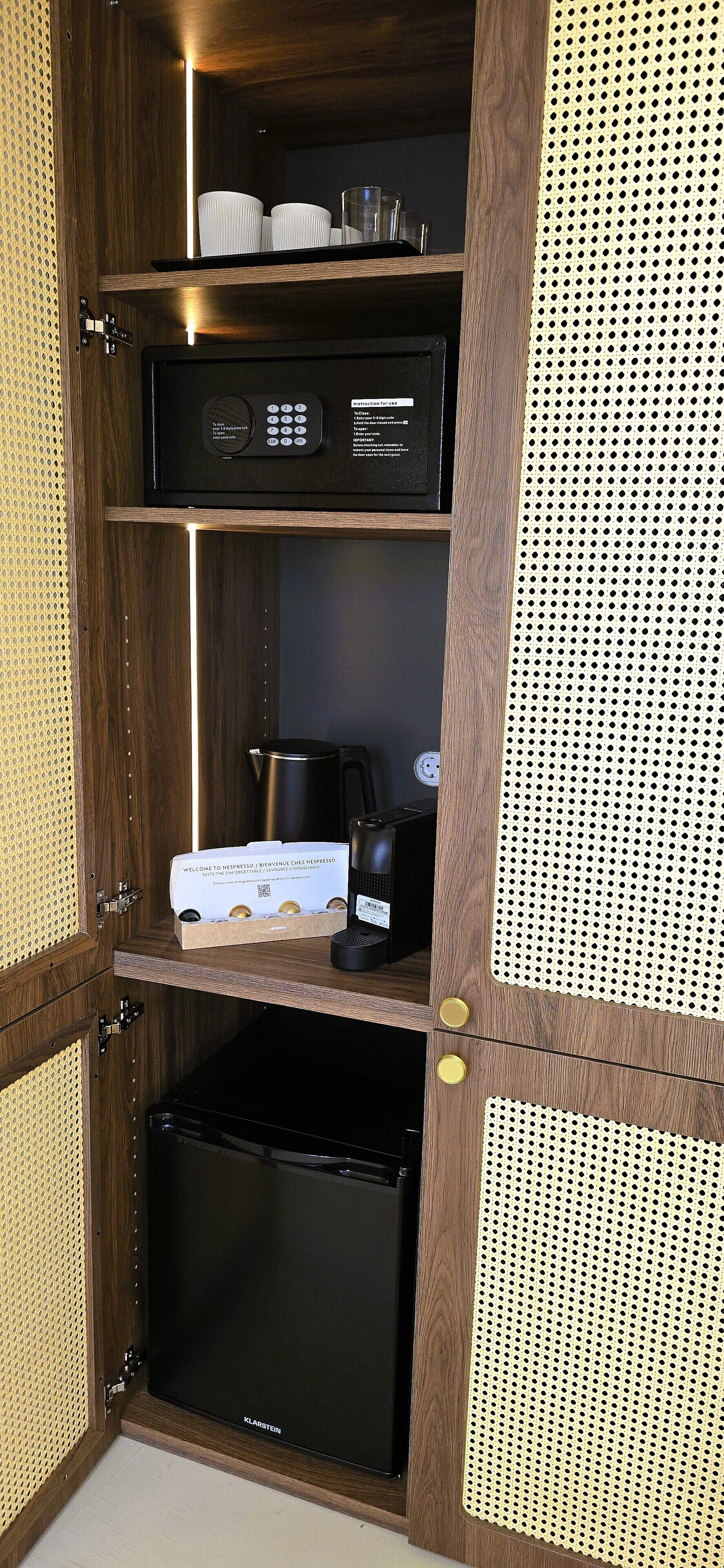 A kitchenette with a coffee maker, a kettle, and a coffee pod dispenser.