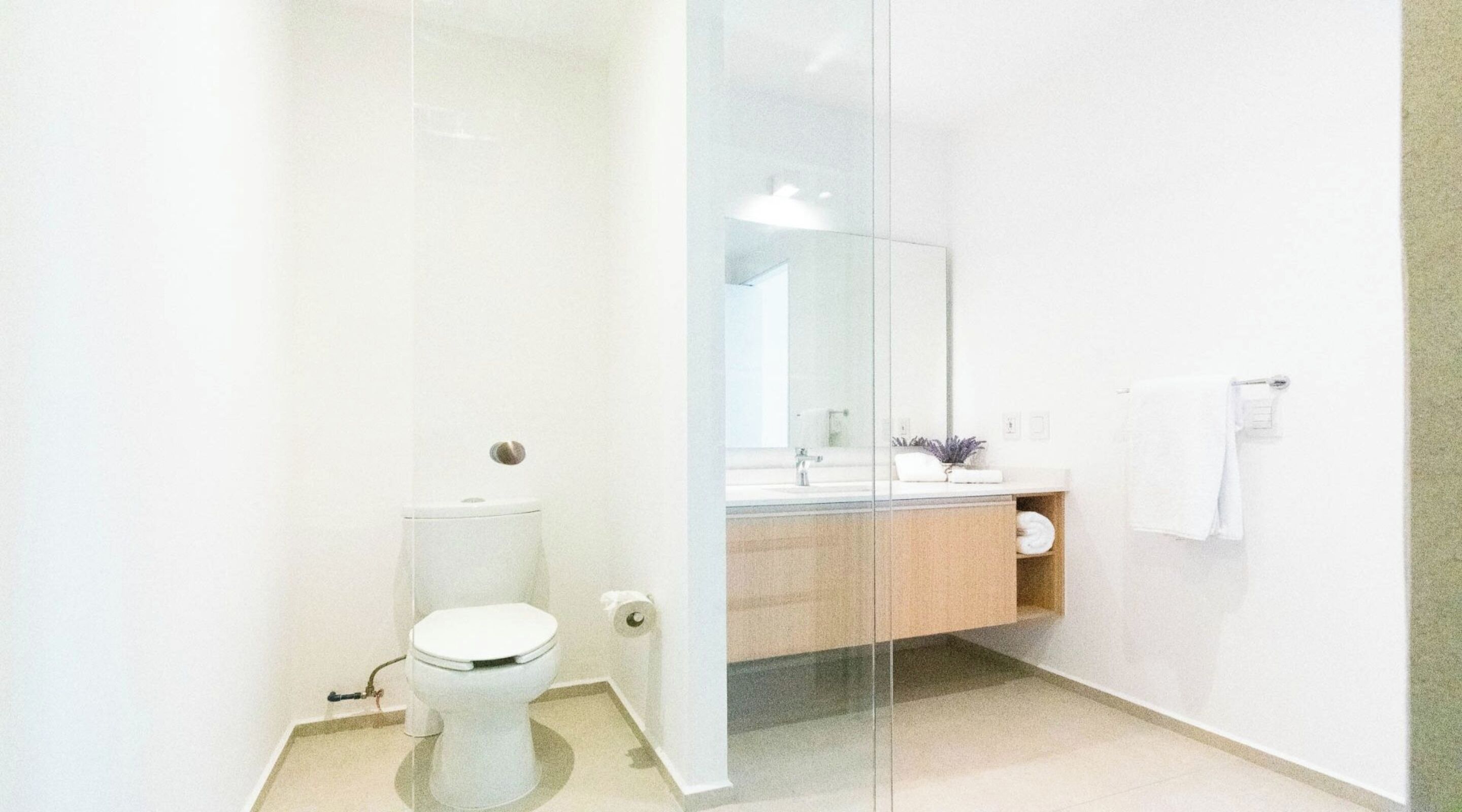 Un baño moderno con inodoro, lavabo y espejo.