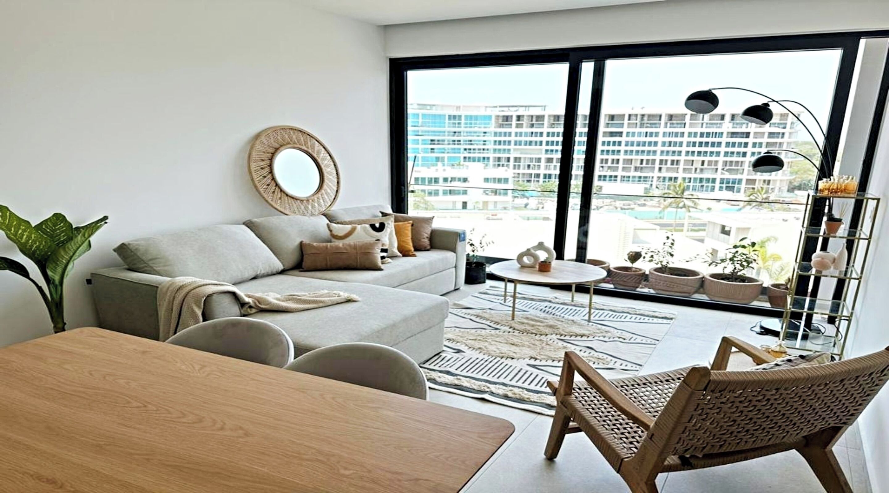 A modern living room with a sofa, coffee table, and a dining area.