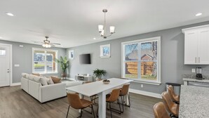 A modern kitchen with white cabinets, a granite countertop, and a built-in oven. - Cozy 3BR Home - Fire Pit & Gated Parking in Midtown - Near Rhodes College & Zoo (Memphis)