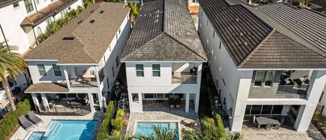 A modern residential complex with multiple houses, a shared swimming pool, and a landscaped garden.