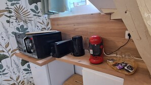 A kitchen counter with a coffee maker, a toaster, and a tray with coffee pods. - Studio Notre Dame 3 in the heart of town, 30 minutes from the Puy du Fou park (Cholet)