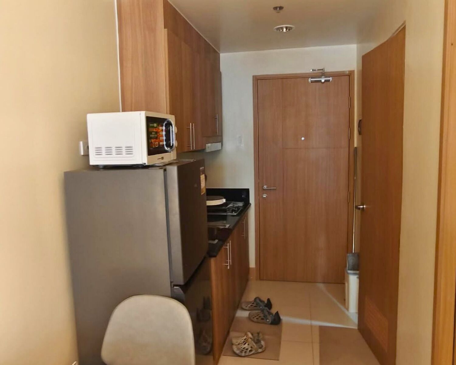 A compact kitchen with a microwave, refrigerator, and a small countertop.