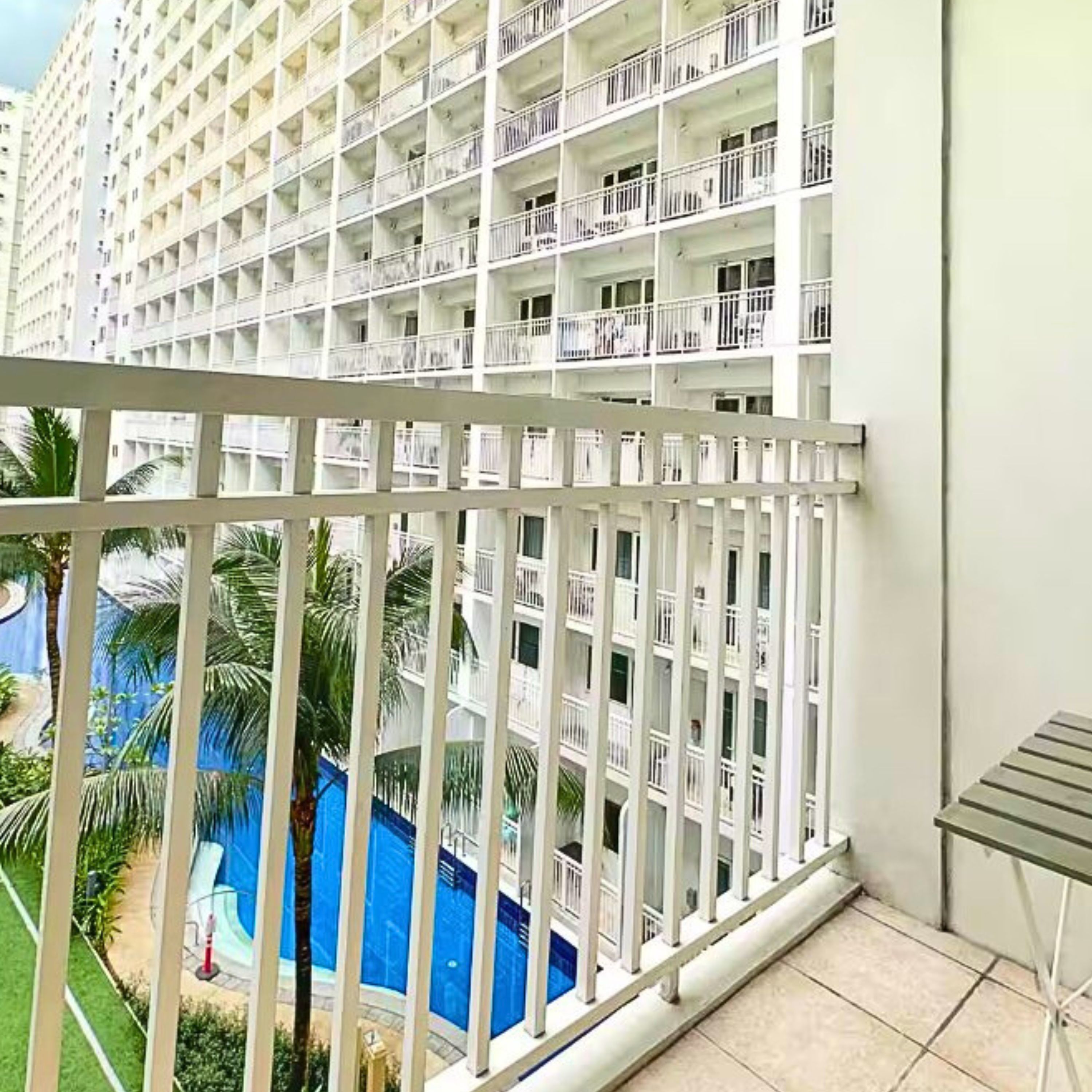A high-rise hotel with multiple balconies and a pool area visible below.
