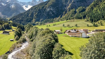 Un paisaje montañoso con un río, casas y un edificio grande con varias habitaciones.