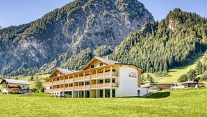 A hotel with a multi-story structure, a balcony, and a mountain backdrop. - Brandnerhus Nr 12 - Balkon 3-zimmer Ferienwohnung (Brand)