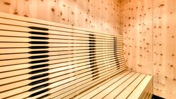 Una sauna in legno con panche a listarelle e parete in legno.