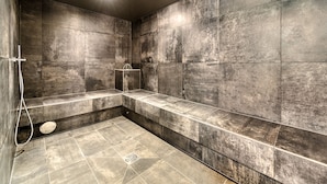 Une salle de bain moderne avec un banc, une douche et un grand miroir.